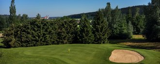 Das Grün der Golfbahn 10 auf der Golfanlage Allgäuer Golf- und Landclub e.V. Ottobeuren mit der Basilika im Hintergrund