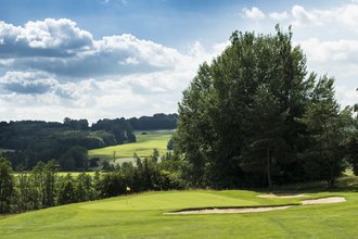 Das Loch 6 auf dem Golfplatz des Allgäuer Golf- und Landclub e.V. mit sanften Hügeln, Bäumen und Buschwerk im Hintergrund (Credit: Stefan von Stengel)