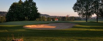 Ein Bunker auf der Golfbahn 04 auf der Golfanlage Allgäuer Golf- und Landclub e.V. Ottobeuren mit der Basilika im Hintergrund