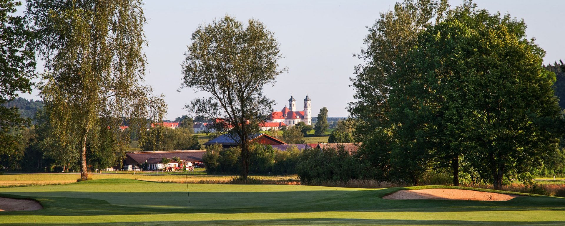 Das Grün der Golfbahn 03 auf der Golfanlage Allgäuer Golf- und Landclub e.V. Ottobeuren mit der Basilika im Hintergrund