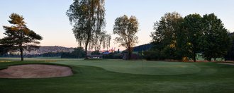 Das Grün der Golfbahn 03 auf der Golfanlage Allgäuer Golf- und Landclub e.V. Ottobeuren mit der Basilika im Hintergrund