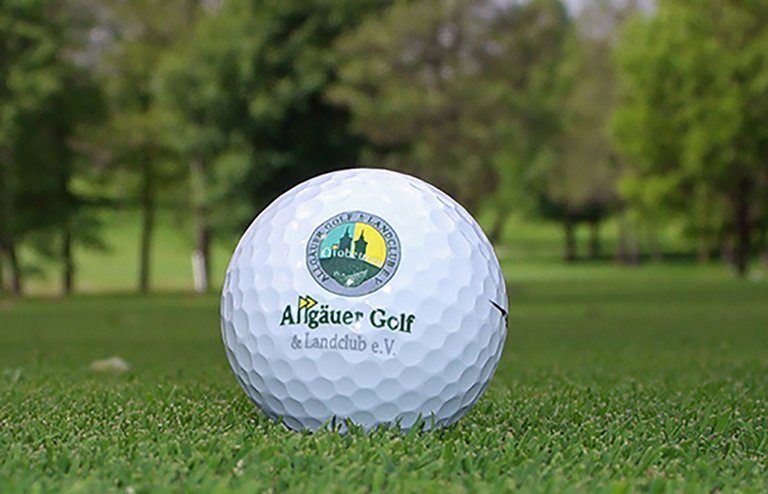 Detailansicht eines Golfballs mit dem Logo des Allgäuer Golf- und Landclub e.V.  auf dem Green liegend