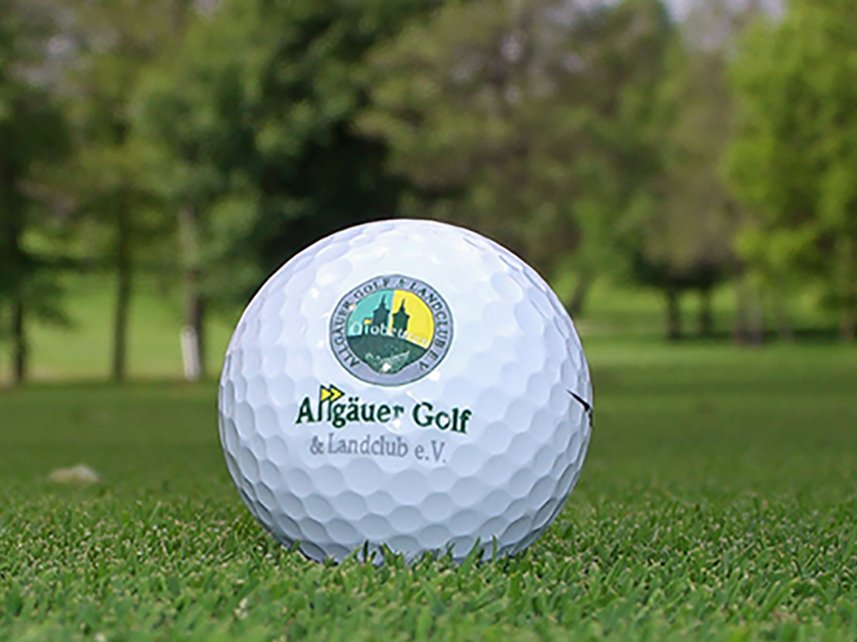 Detailansicht eines Golfballs mit dem Logo des Allgäuer Golf- und Landclub e.V.  auf dem Green liegend